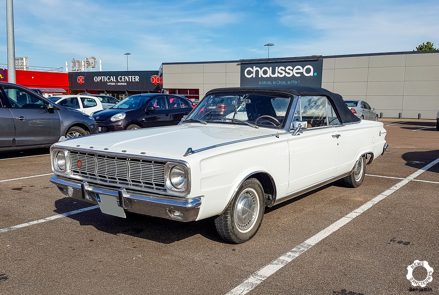 Sur le parking, une Dodge Dart Cabriolet prend un bain de soleil